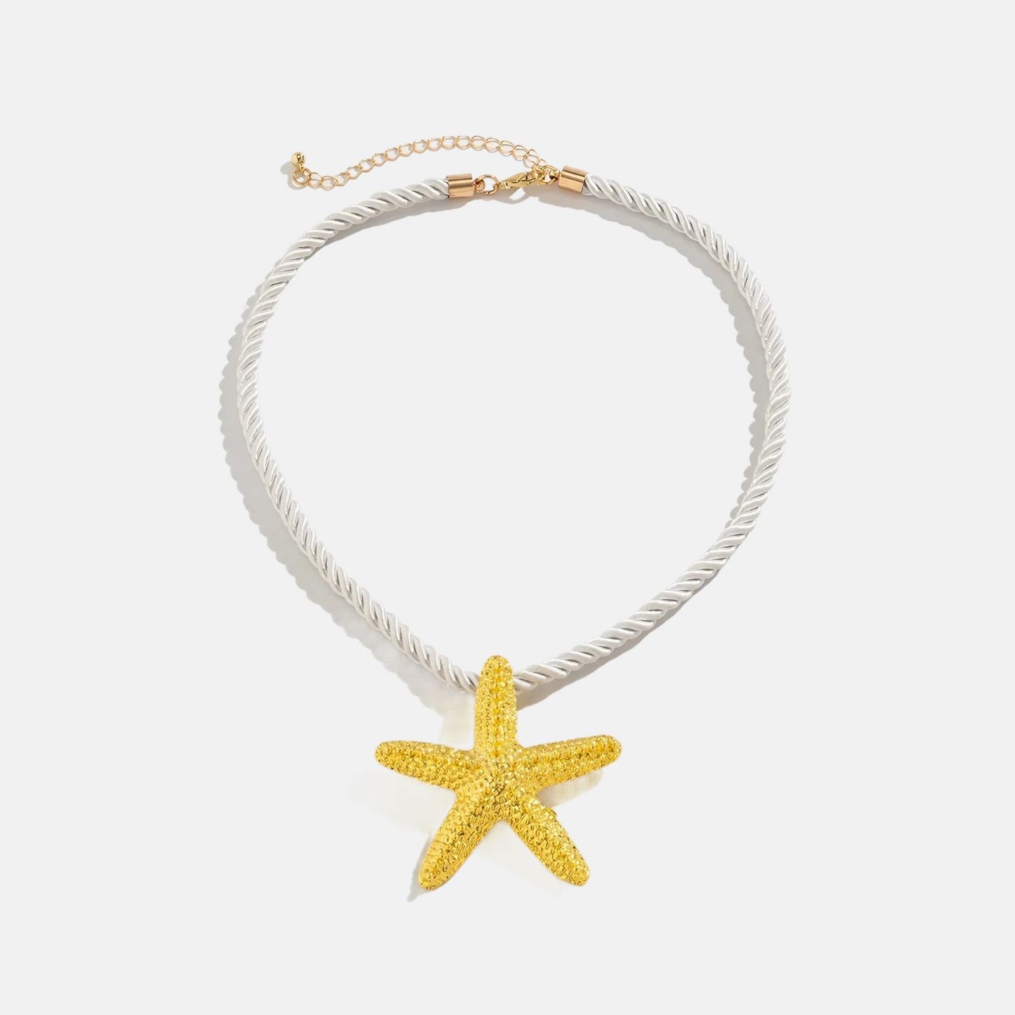 Ce collier étoilé, avec sa corde blanche nouée d'or, évoque la beauté intemporelle des trésors marins