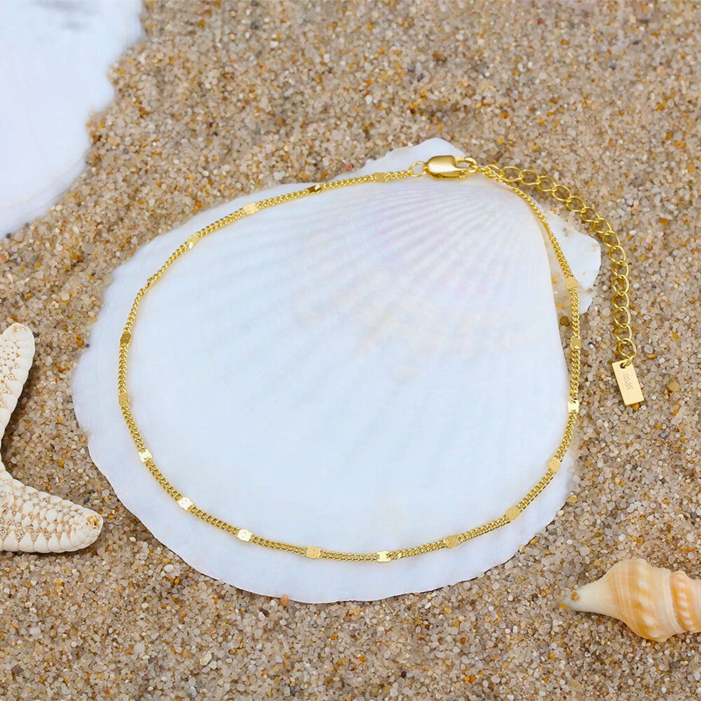 Un éclat doré reposant délicatement sur un lit de sable, rappelant les trésors inestimables enfouis au cœur des océans