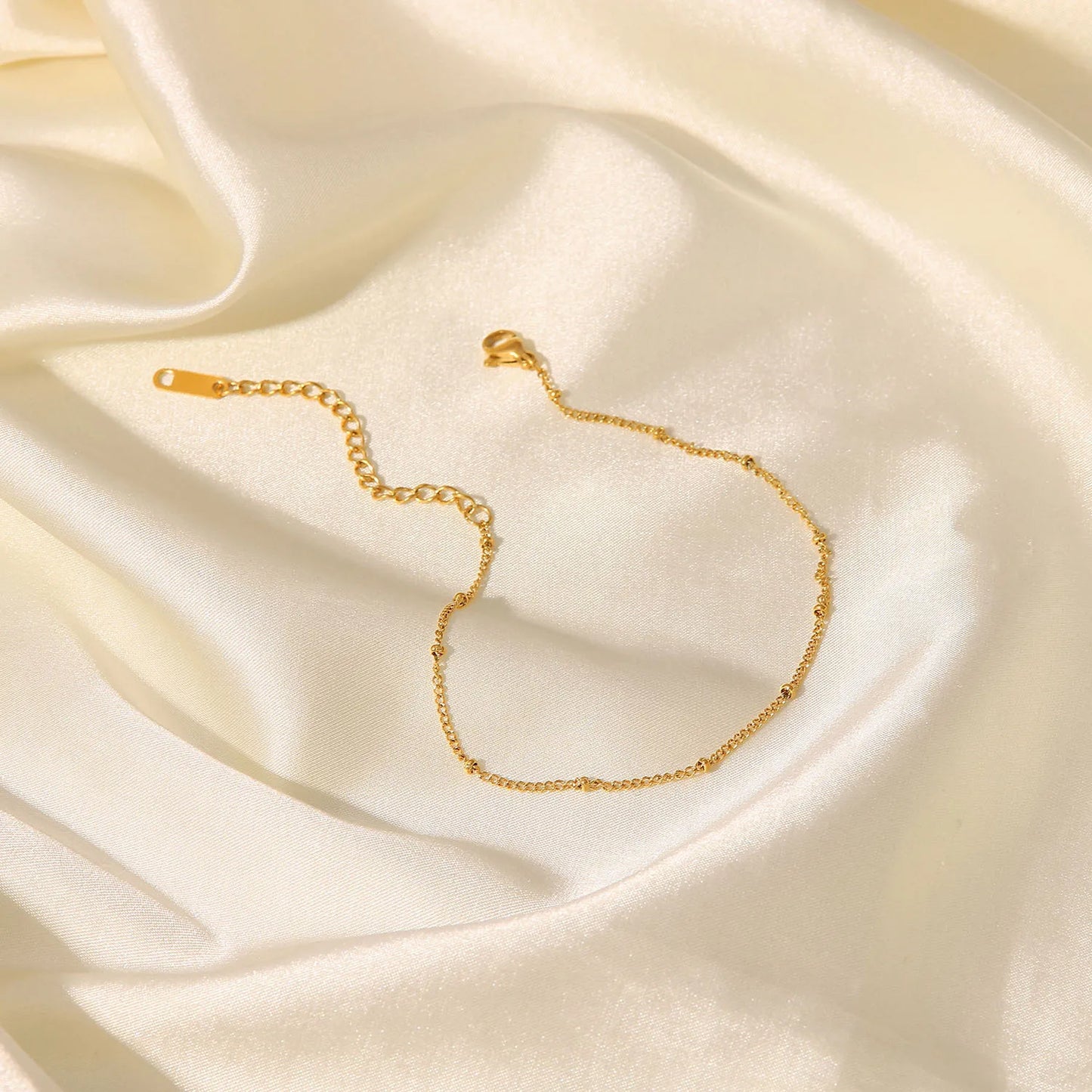 Comme un fil d'or tissé par les dieux marins, cette chaîne enlace la cheville avec la délicatesse des vagues dorées sous le soleil couchant