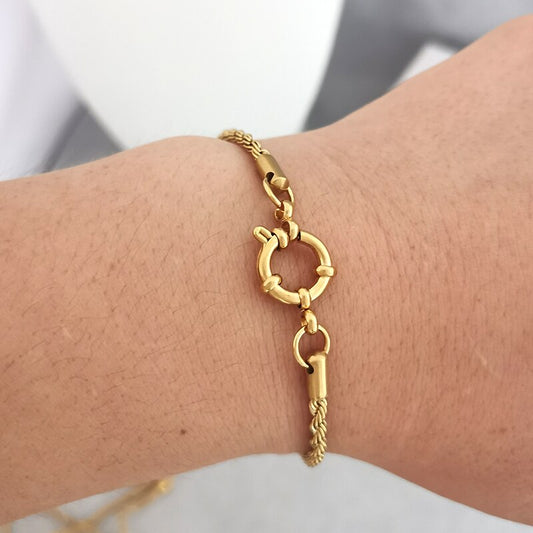 Tel un cordage doré noué par les vagues, ce bracelet embrasse le poignet avec la tendresse du vent marin sous un soleil éclatant