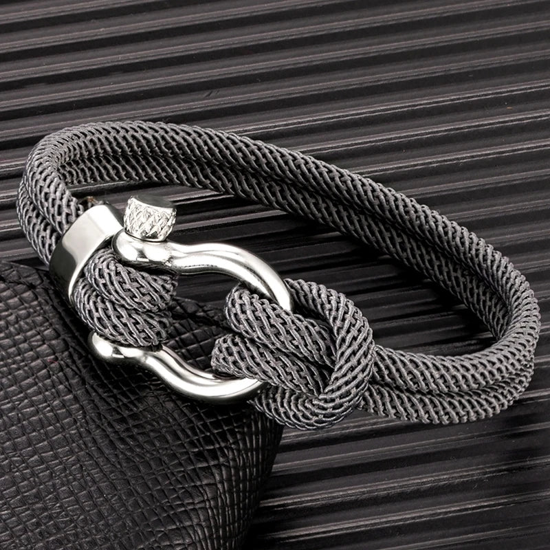 Un bracelet élégant avec un design marin, composé de corde tressée et d'un fermoir en métal brillant