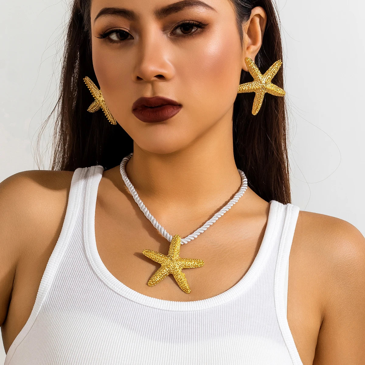Ce collier étoilé, avec sa corde blanche nouée d'or, évoque la beauté intemporelle des trésors marins