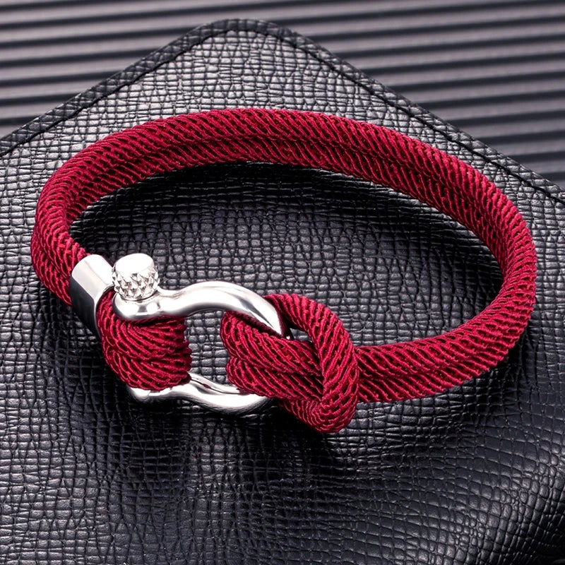 Un bracelet élégant avec un design marin, composé de corde tressée et d'un fermoir en métal brillant