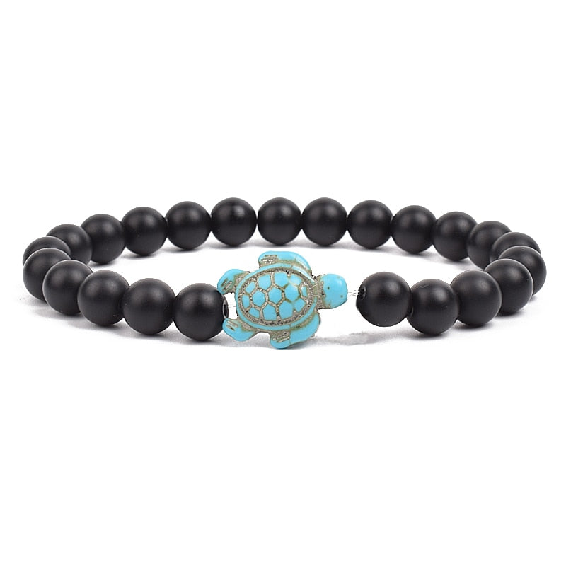 Ce bracelet de perles, orné d'une tortue délicate, brille comme un trésor rare trouvé dans les profondeurs des océans, prêt à enchanter celui qui le porte