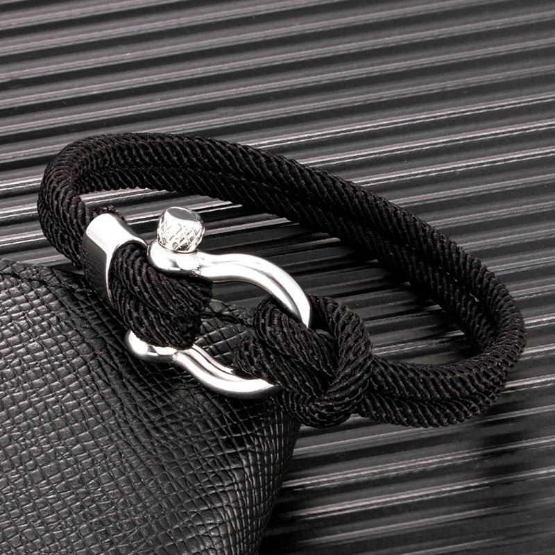 Un bracelet élégant avec un design marin, composé de corde tressée et d'un fermoir en métal brillant