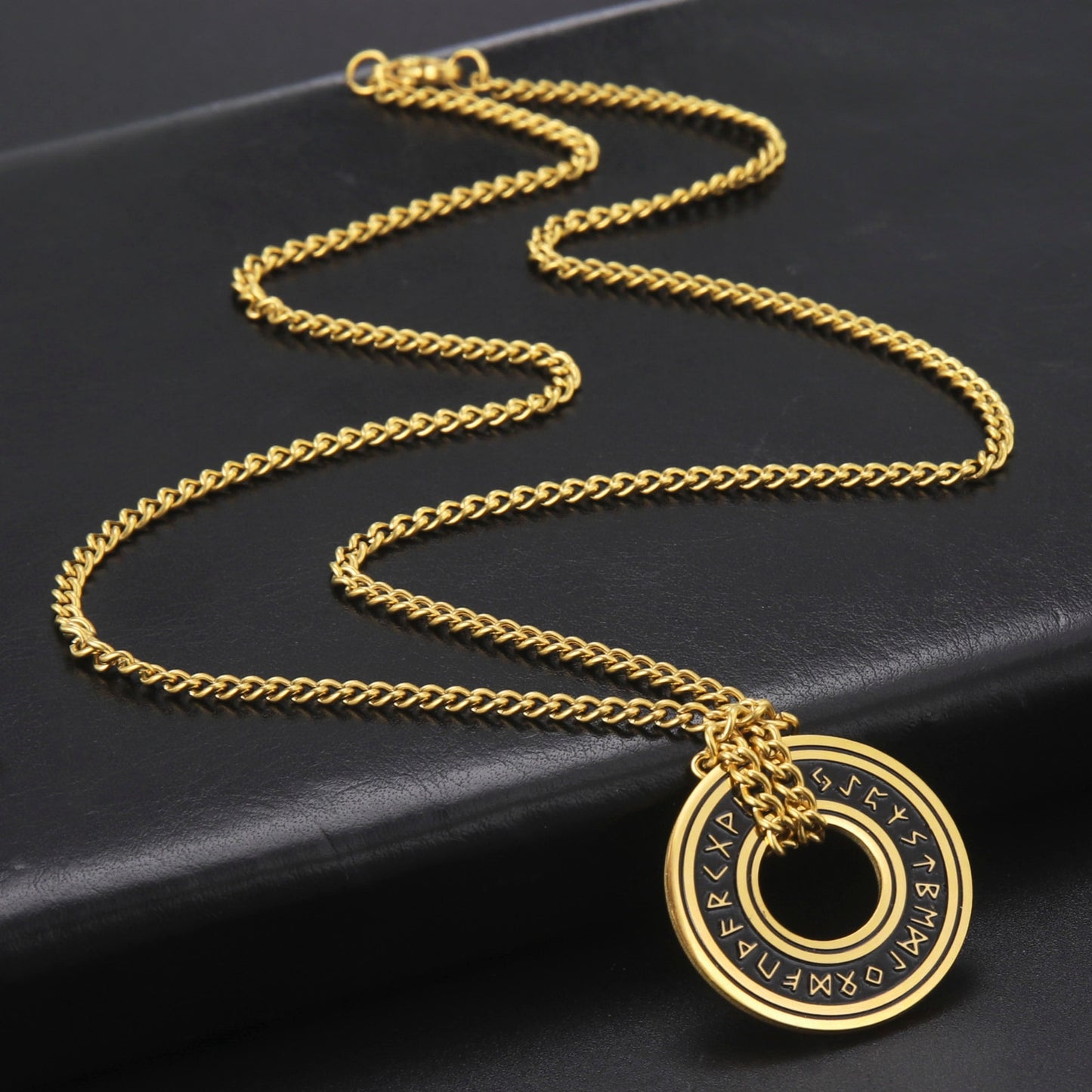 Ce pendentif en argent, gravé de runes mystérieuses, est suspendu à un élégant cordon noir, évoquant la profondeur et le mystère des océans