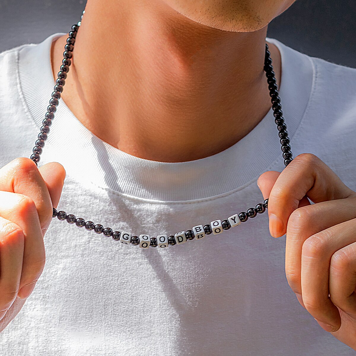 Ce collier en perles noires, avec ses lettres blanches formant "GOOD BOY", évoque l'élégance brute et l'esprit aventureux des marins sillonnant les vastes océans