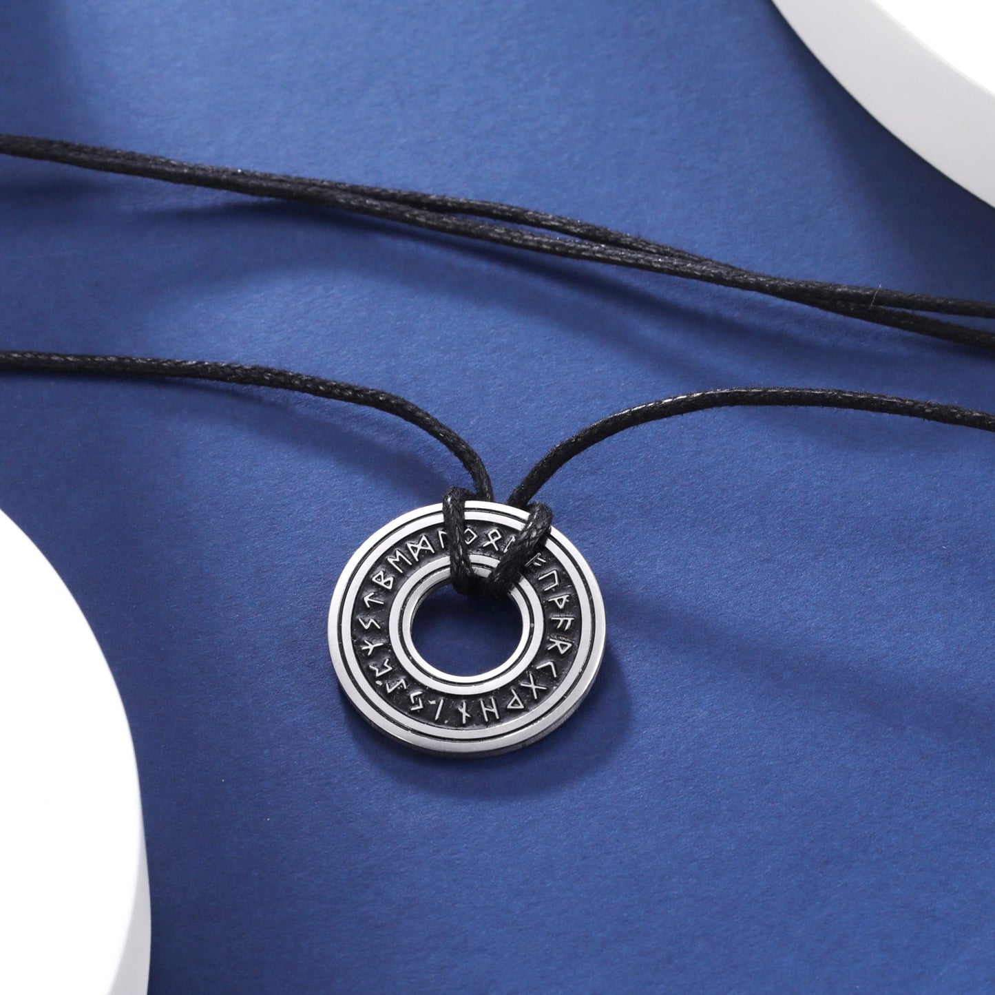 Ce pendentif en argent, gravé de runes mystérieuses, est suspendu à un élégant cordon noir, évoquant la profondeur et le mystère des océans