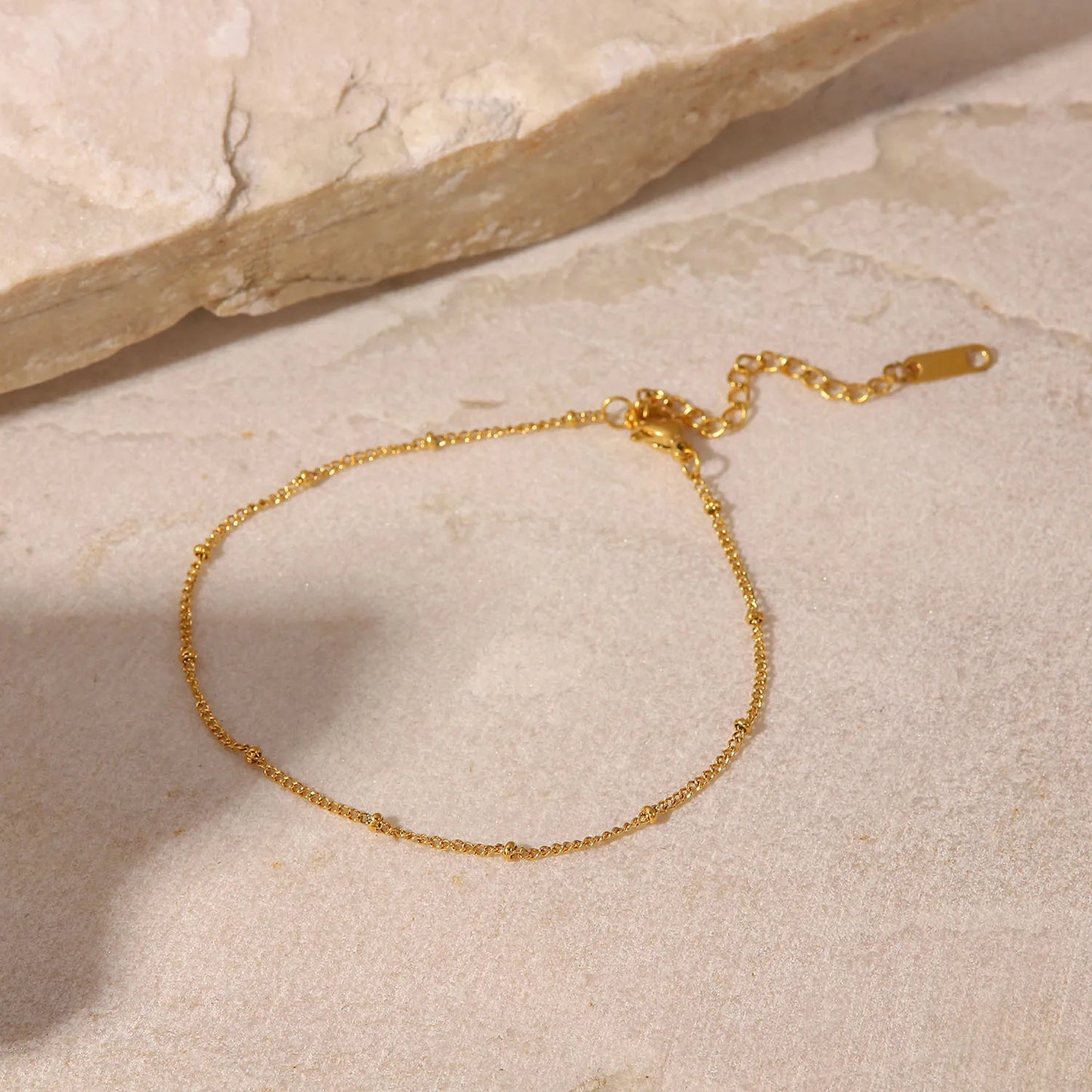 Comme un fil d'or tissé par les dieux marins, cette chaîne enlace la cheville avec la délicatesse des vagues dorées sous le soleil couchant