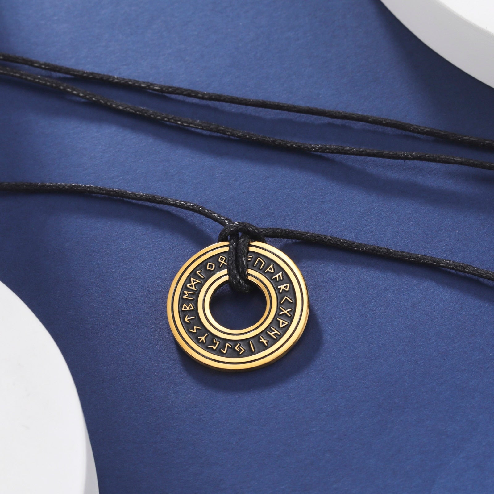 Ce pendentif en argent, gravé de runes mystérieuses, est suspendu à un élégant cordon noir, évoquant la profondeur et le mystère des océans