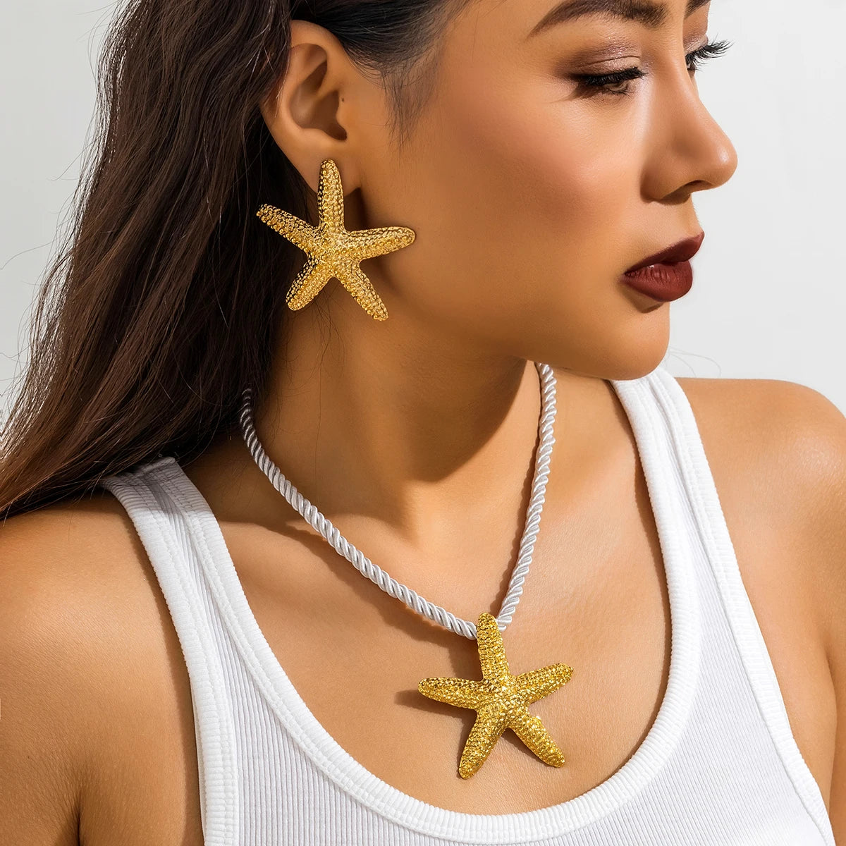 Ce collier étoilé, avec sa corde blanche nouée d'or, évoque la beauté intemporelle des trésors marins