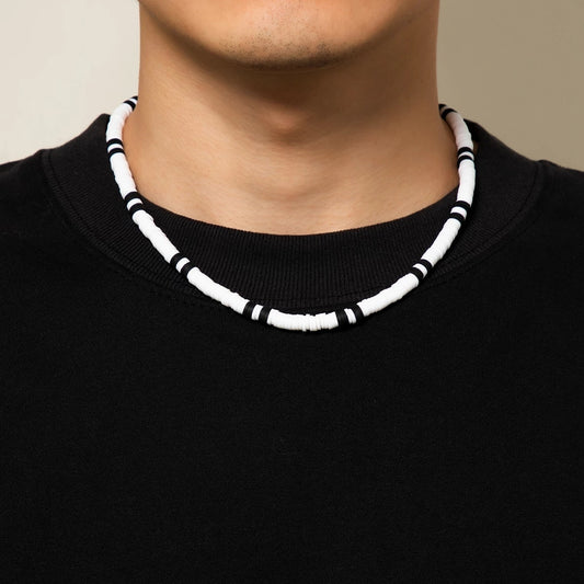 Collier surf homme en perles d'argile - Mer Aux TrésorsLes perles d'argile blanche et noire de ce collier évoquent les vagues écumantes et les horizons lointains que seul un marin ose braver
