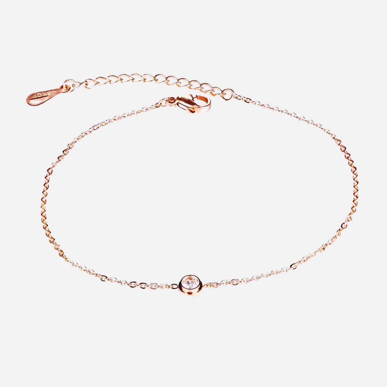 Comme une goutte d'or pure, ce bracelet fin enlace la cheville avec la douceur d'une vague au coucher du soleil, portant en son cœur une gemme scintillante comme l'étoile du matin sur la mer calme