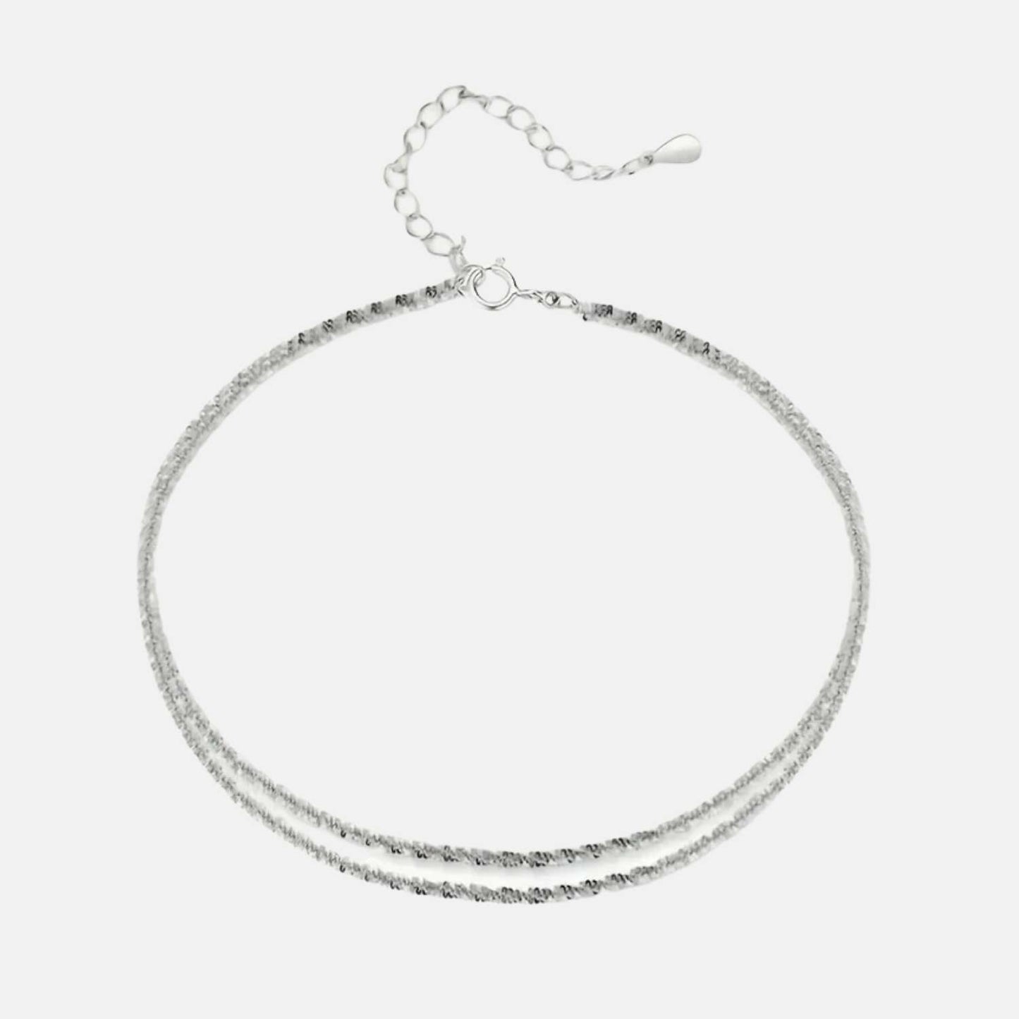 Tel un rayon de lune caressant la mer à l'aube, cette chaînette d'argent enlace la cheville avec une élégance intemporelle, reflet d'un éclat céleste