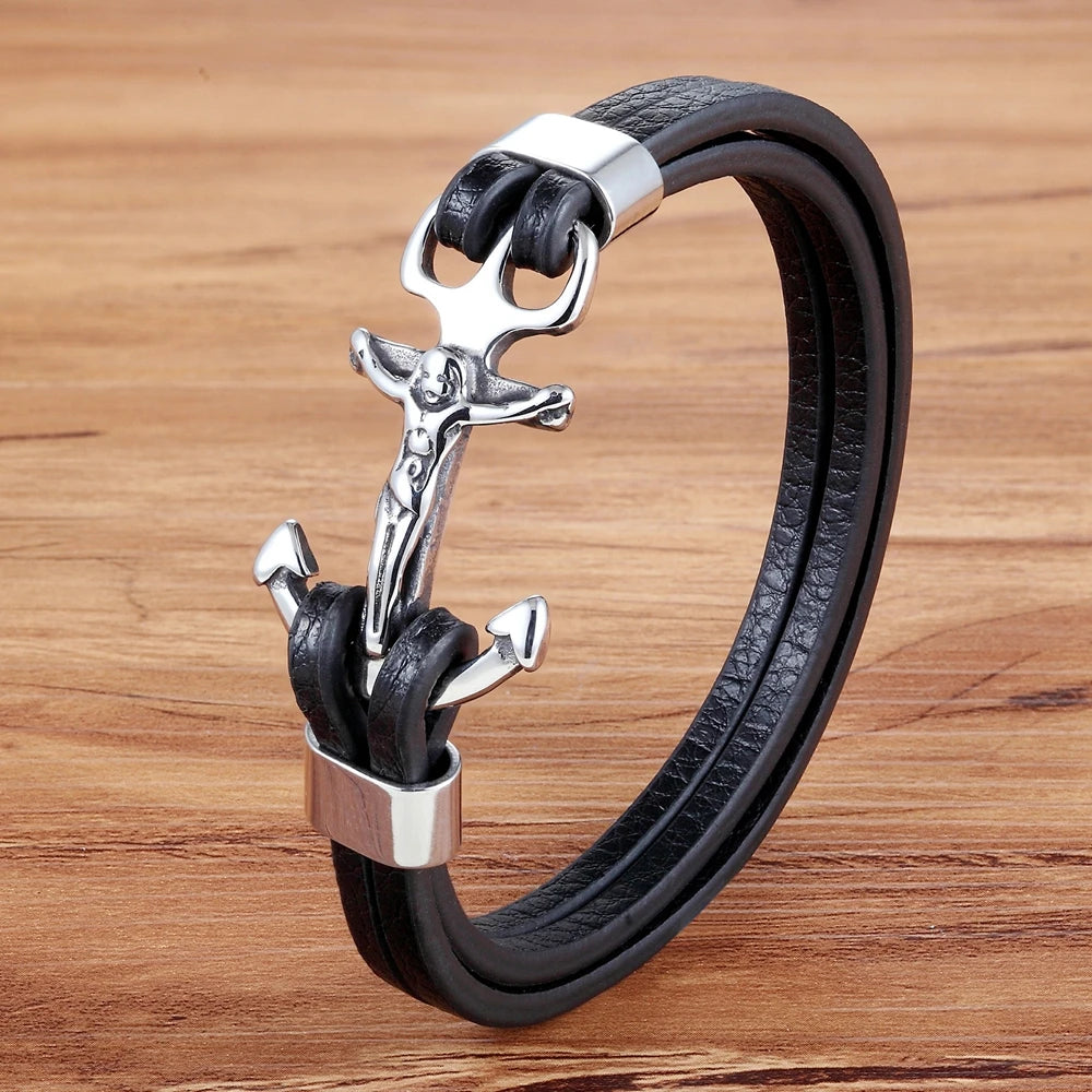 Un élégant bracelet en cuir noir est orné d'une ancre en métal argenté, stylisée avec une silhouette humaine cruciforme