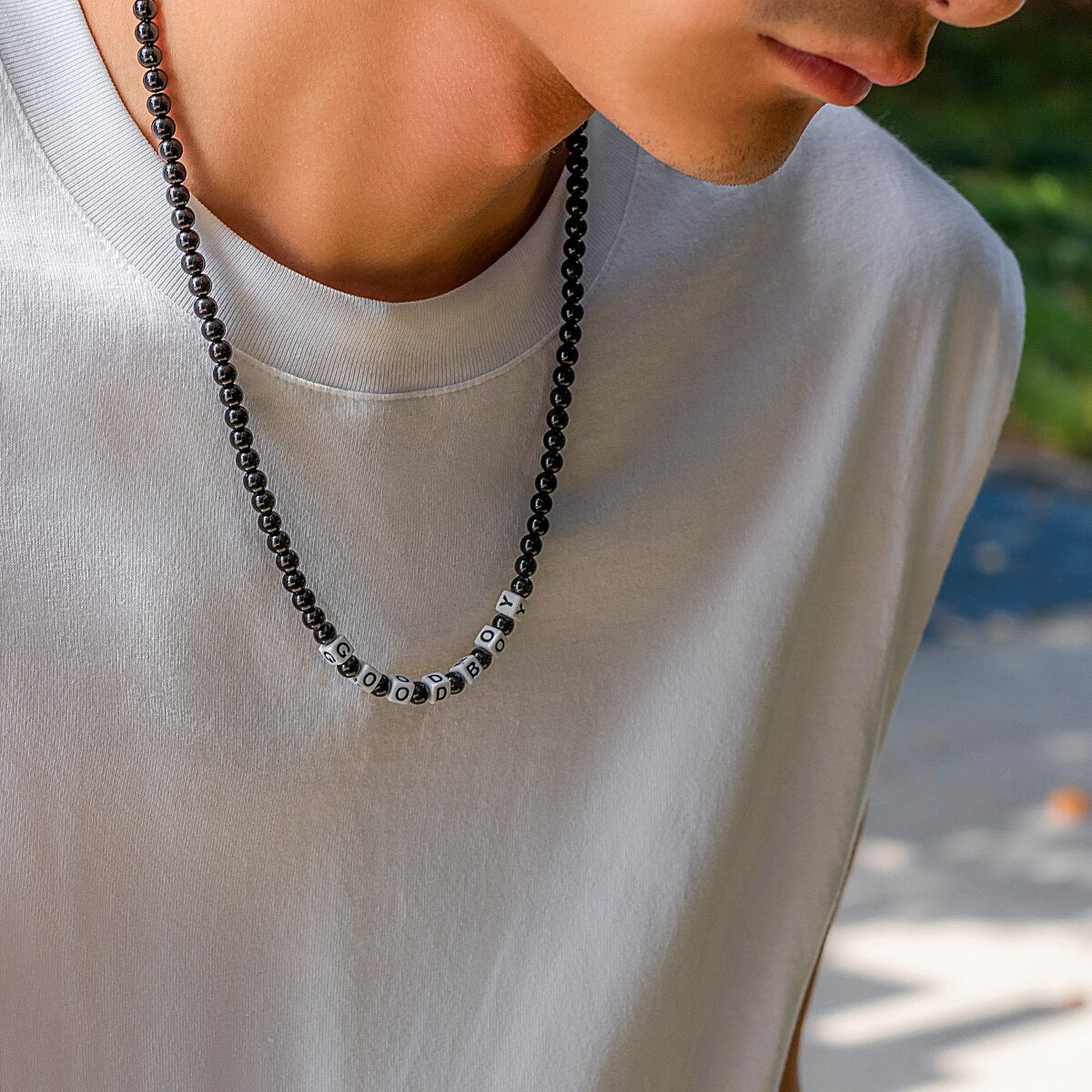 Ce collier en perles noires, avec ses lettres blanches formant "GOOD BOY", évoque l'élégance brute et l'esprit aventureux des marins sillonnant les vastes océans