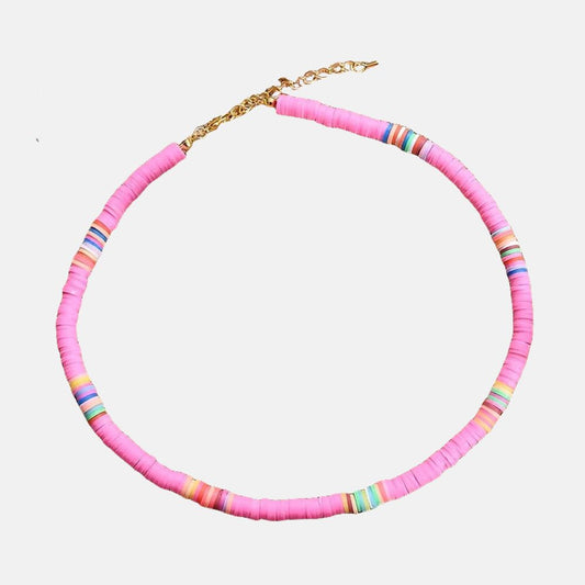 Ce collier en perles roses et multicolores évoque les couleurs chatoyantes d'un coucher de soleil sur l'océan
