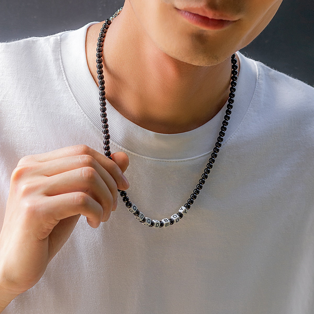 Ce collier en perles noires, avec ses lettres blanches formant "GOOD BOY", évoque l'élégance brute et l'esprit aventureux des marins sillonnant les vastes océans